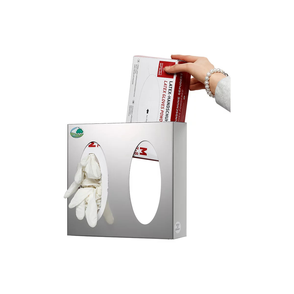Hand placing latex gloves into dispenser. Dispenser is metal with two openings. One contains gloves.