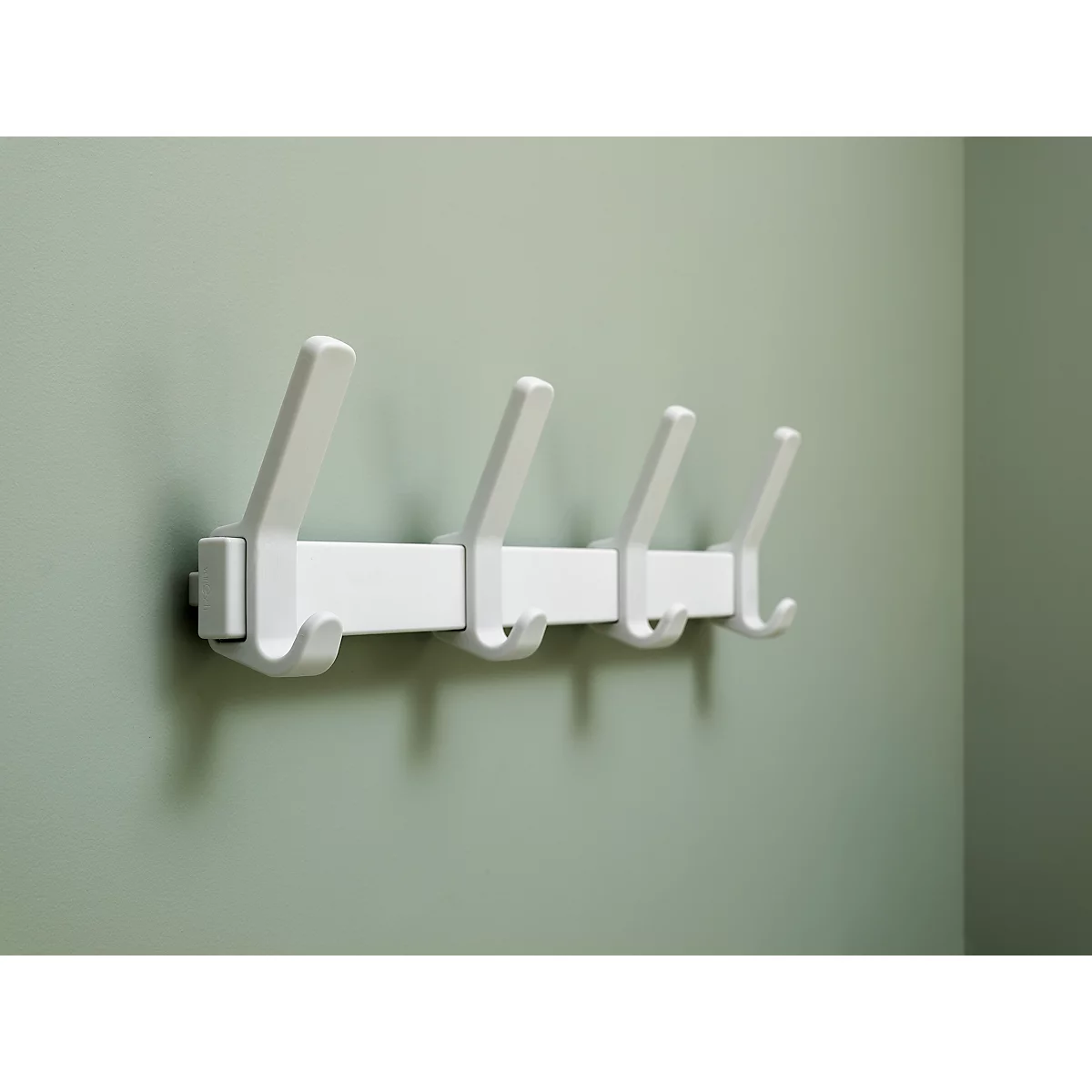 Weisser Wandhaken mit vier Haken vor hellgrüner Wand.