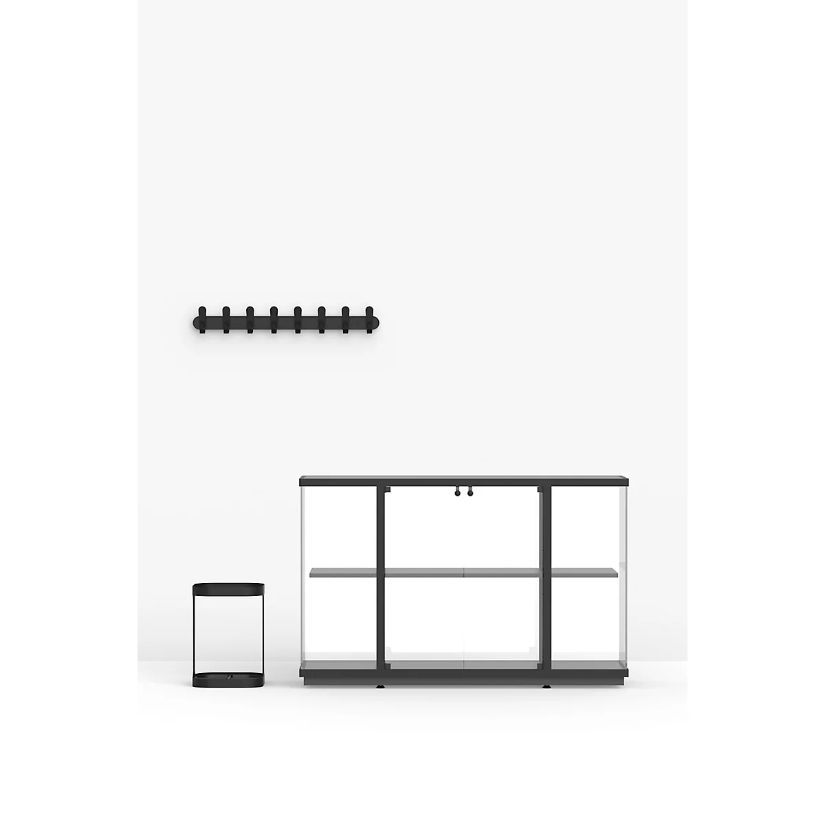Präsentation von drei schwarzen Möbelstücken vor weißem Hintergrund: eine Glasvitrine, ein Hocker und eine Garderobe.
