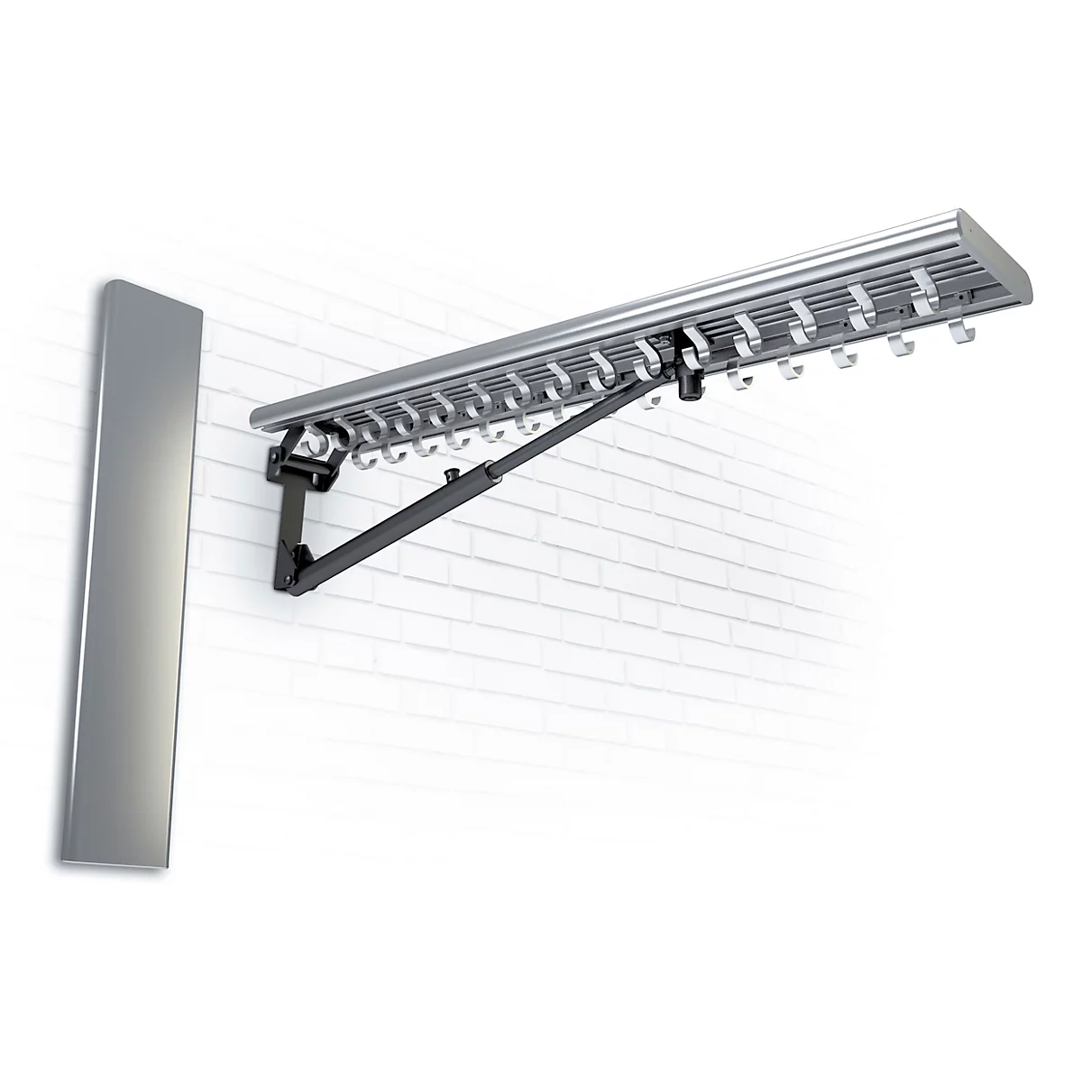 Wäschetrockner, an einer Wand befestigt, aus silberfarbenem Metall. Schwarze Gelenkarme. Helle Backsteinmauer.