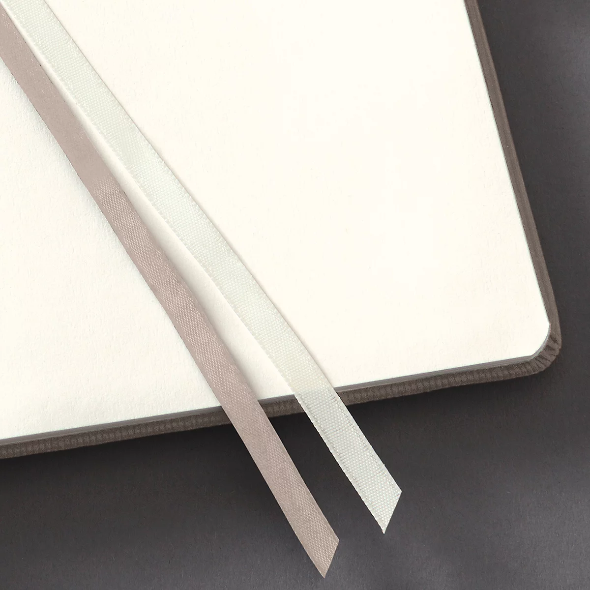 Close-up van een open notitieboek met twee gekleurde bladwijzers.