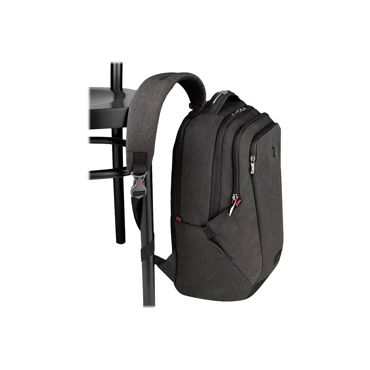 Dunkelgrauer Rucksack an einem schwarzen Tisch. Der Rucksack hat mehrere Fächer und Reißverschlüsse.