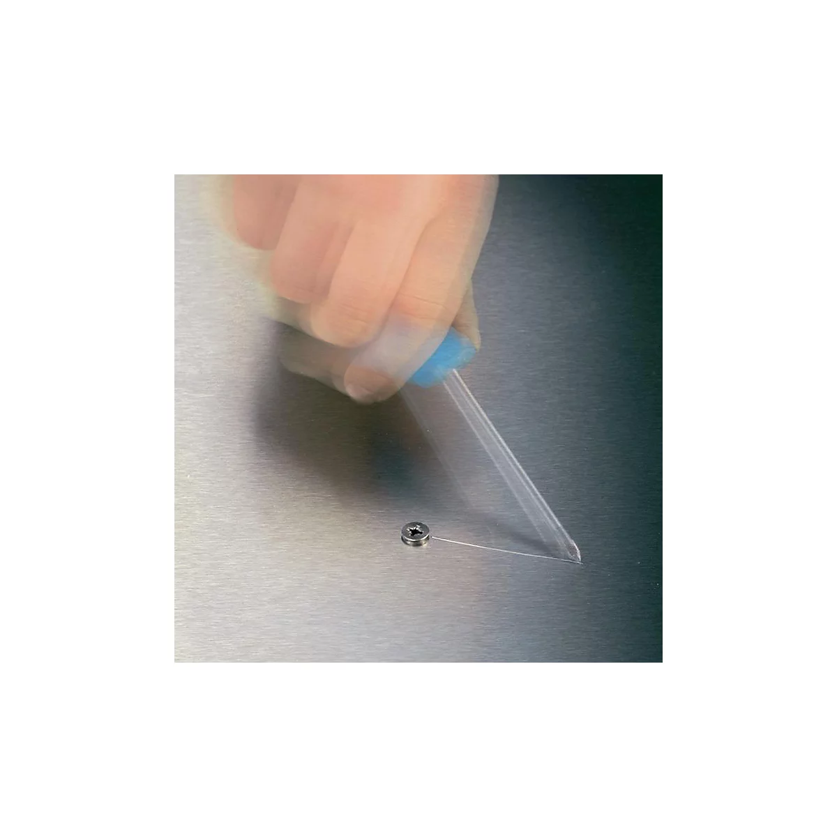 Main floue avec un tournevis fixant une vis sur une surface métallique.