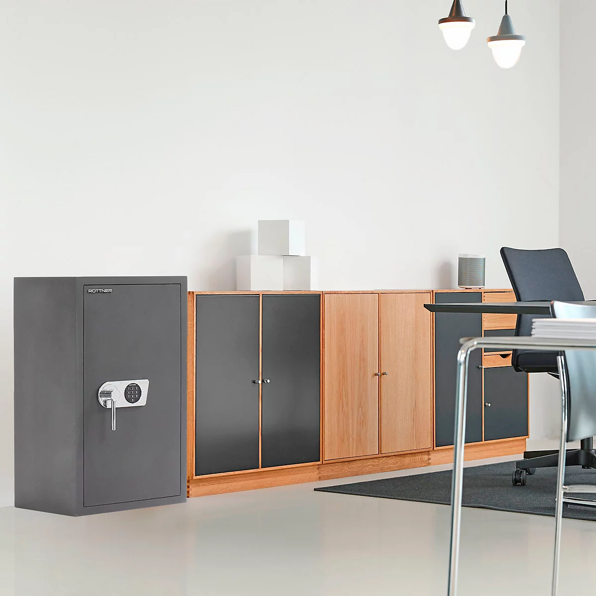Grauer Tresor in einem Büro, daneben Schränke und Schreibtisch.