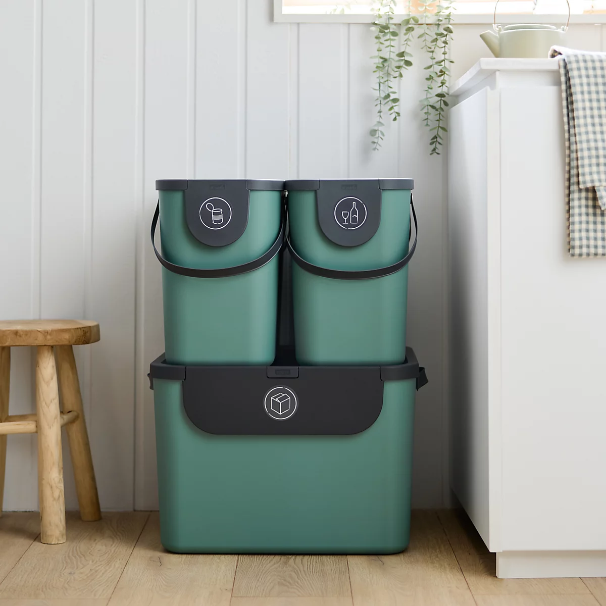 Hellgrüne Aufbewahrungsbox mit schwarzem Deckel und Aufklebern für Mülltrennung.