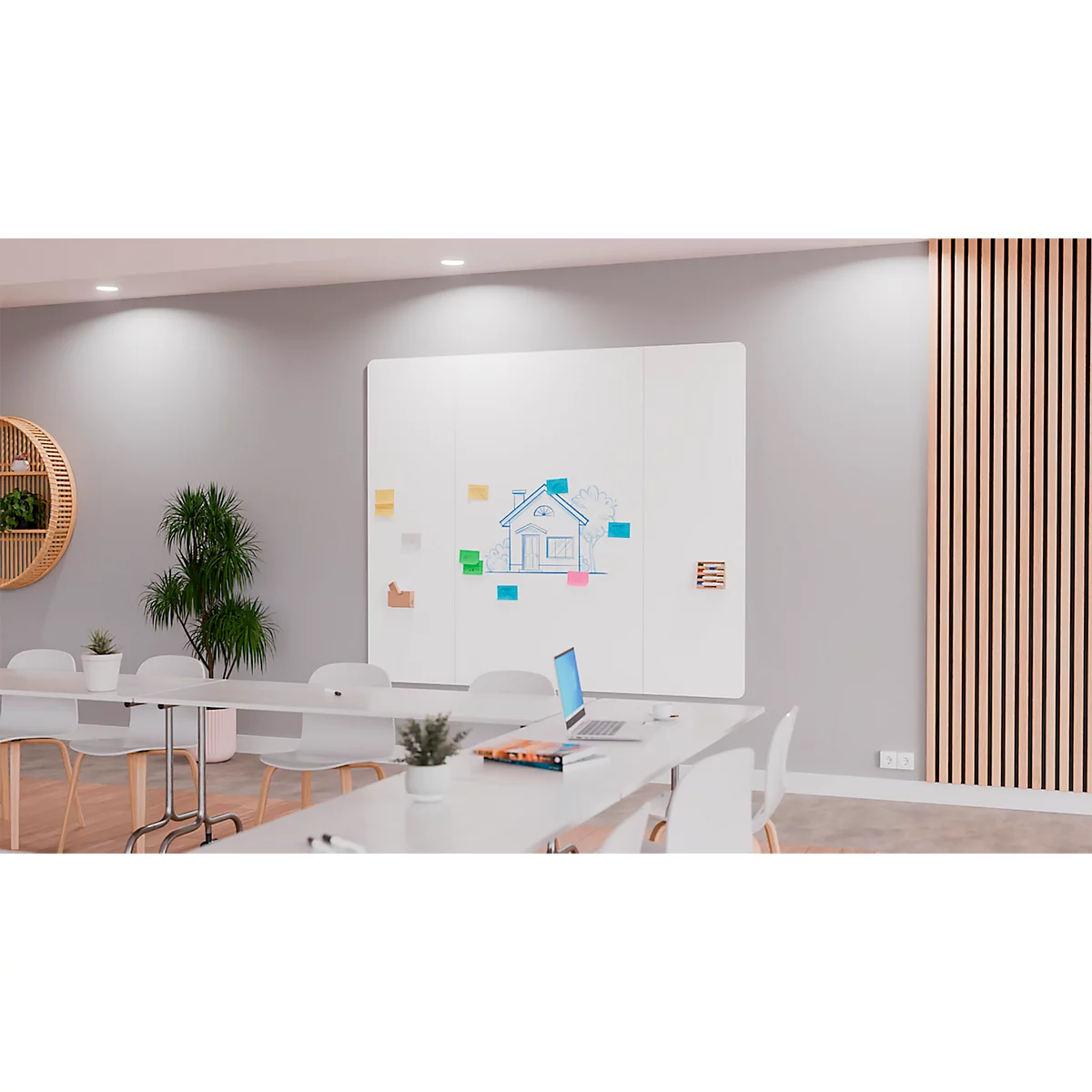 Büro mit weißem Board, Skizze eines Hauses, Post-it-Notizen und Laptop. Eine helle, moderne Arbeitsumgebung.