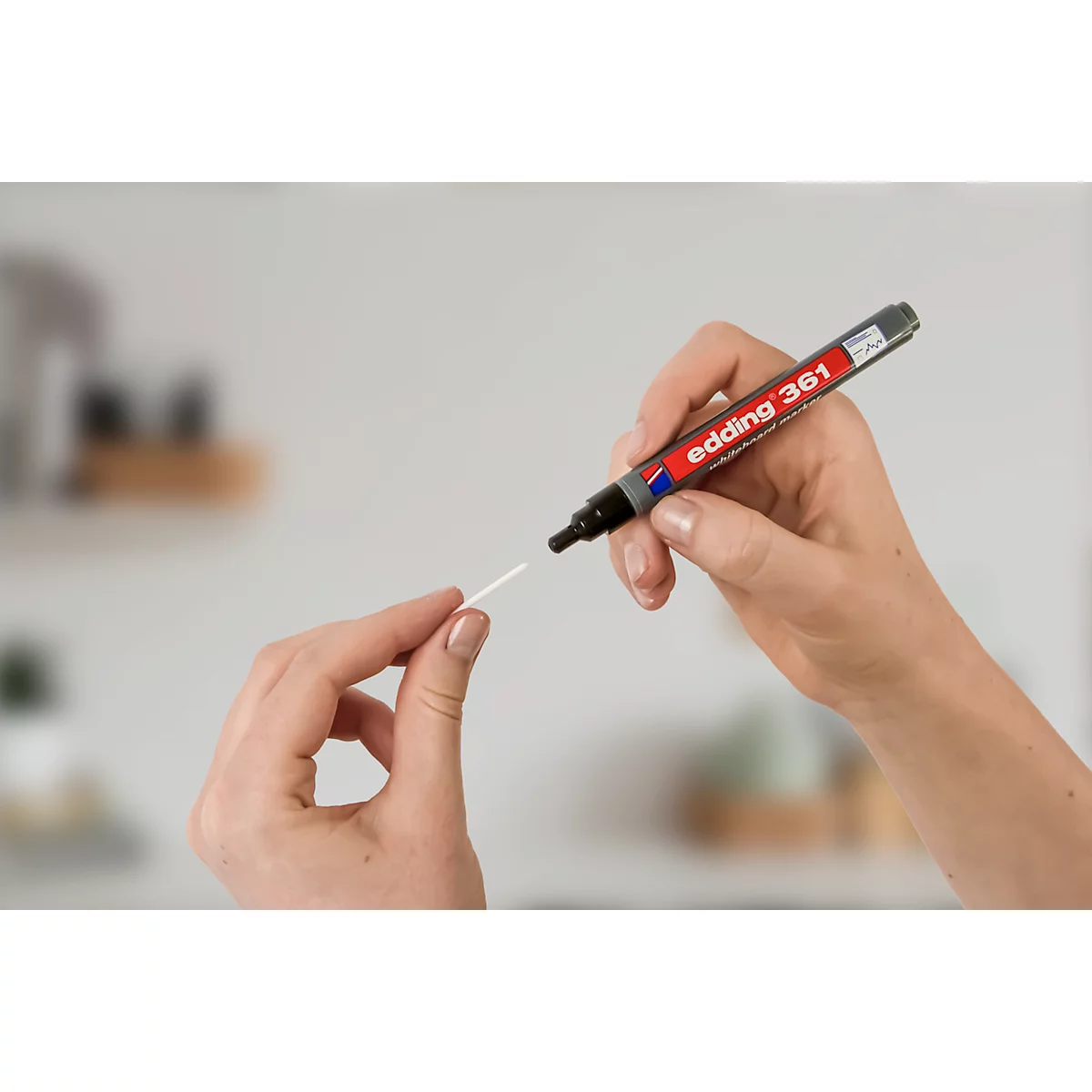 Hände halten einen Edding 361 Filzstift und einen weißen Stab. Der Stift wird gerade benutzt.