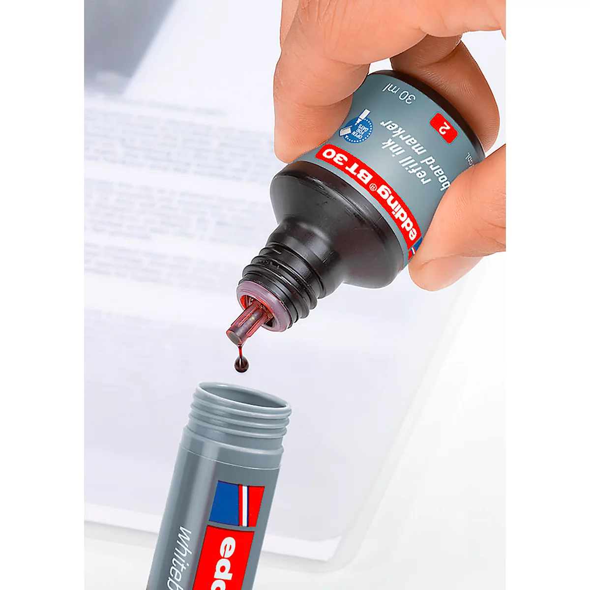 Nachfülltinte tropft aus der Flasche in einen Edding-Marker. Aufschrift: Edding BT30.