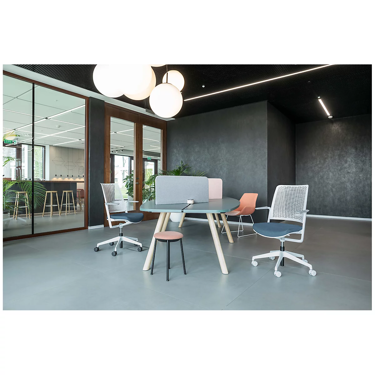 Office with desk, chairs and round lamps. Windows and a dark wall in the background.