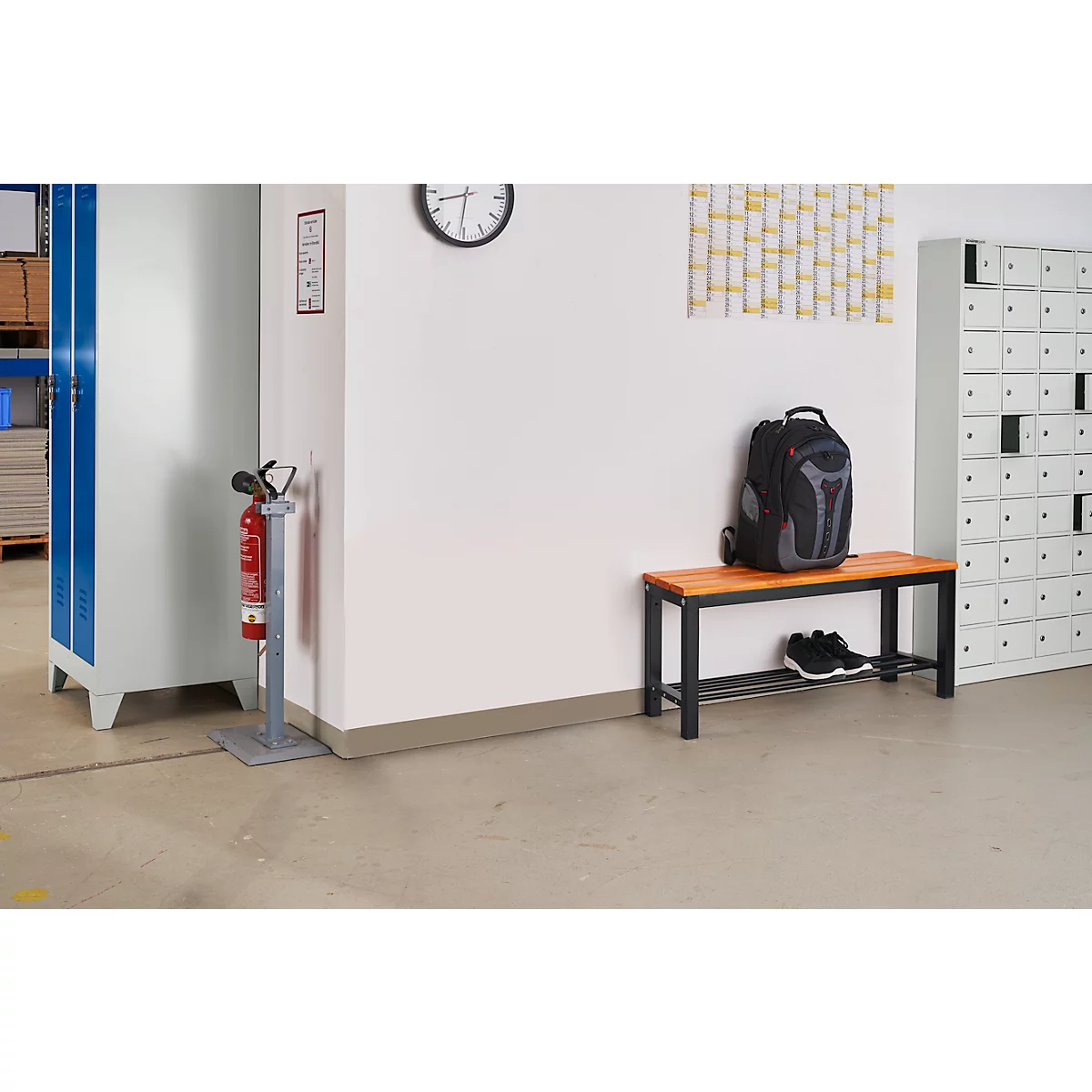 An interior shows lockers, a bench with backpack and shoes, a clock, and a fire extinguisher.