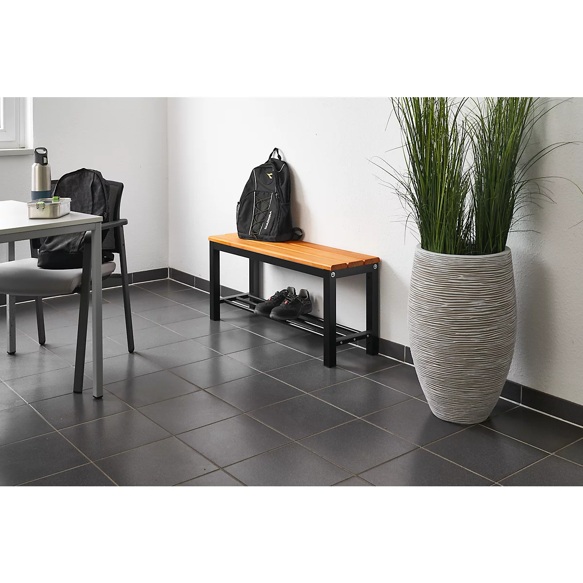 Hallway featuring a bench, chair, pot with tall grass, and shoes.