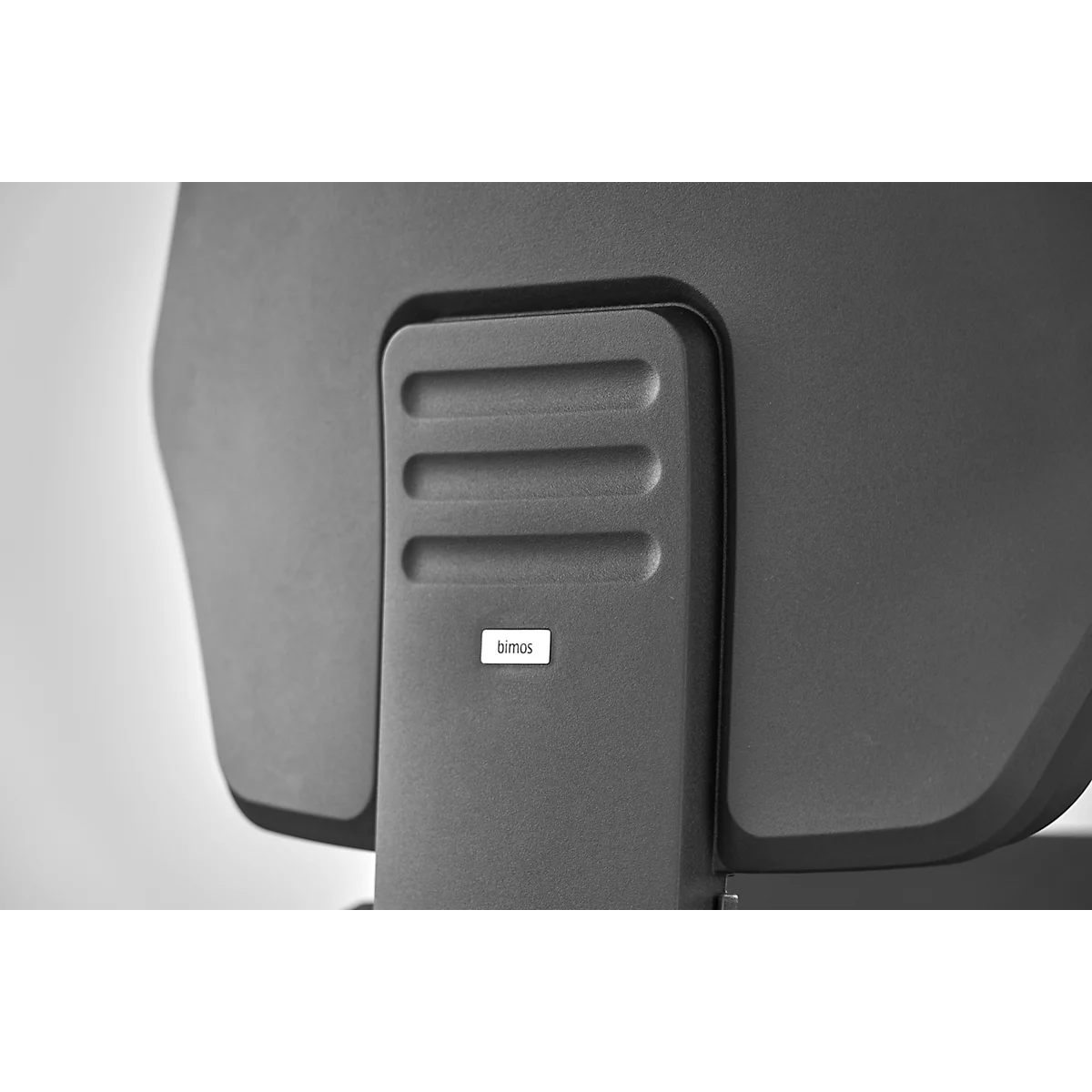 Grey office chair detail: Backrest with three horizontal grooves and sticker with the inscription "bemos".