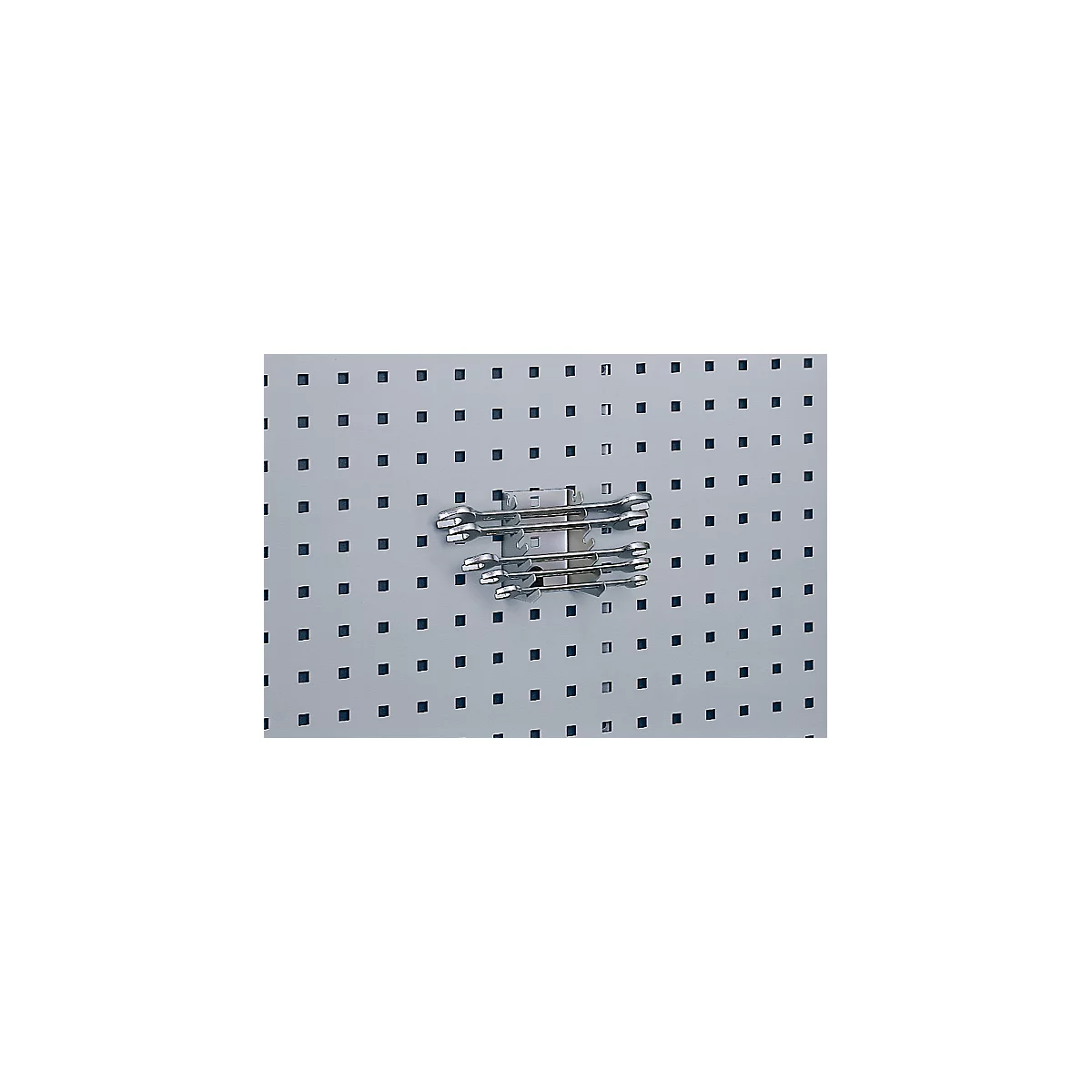 Several wrenches are attached to a pegboard with a holder.