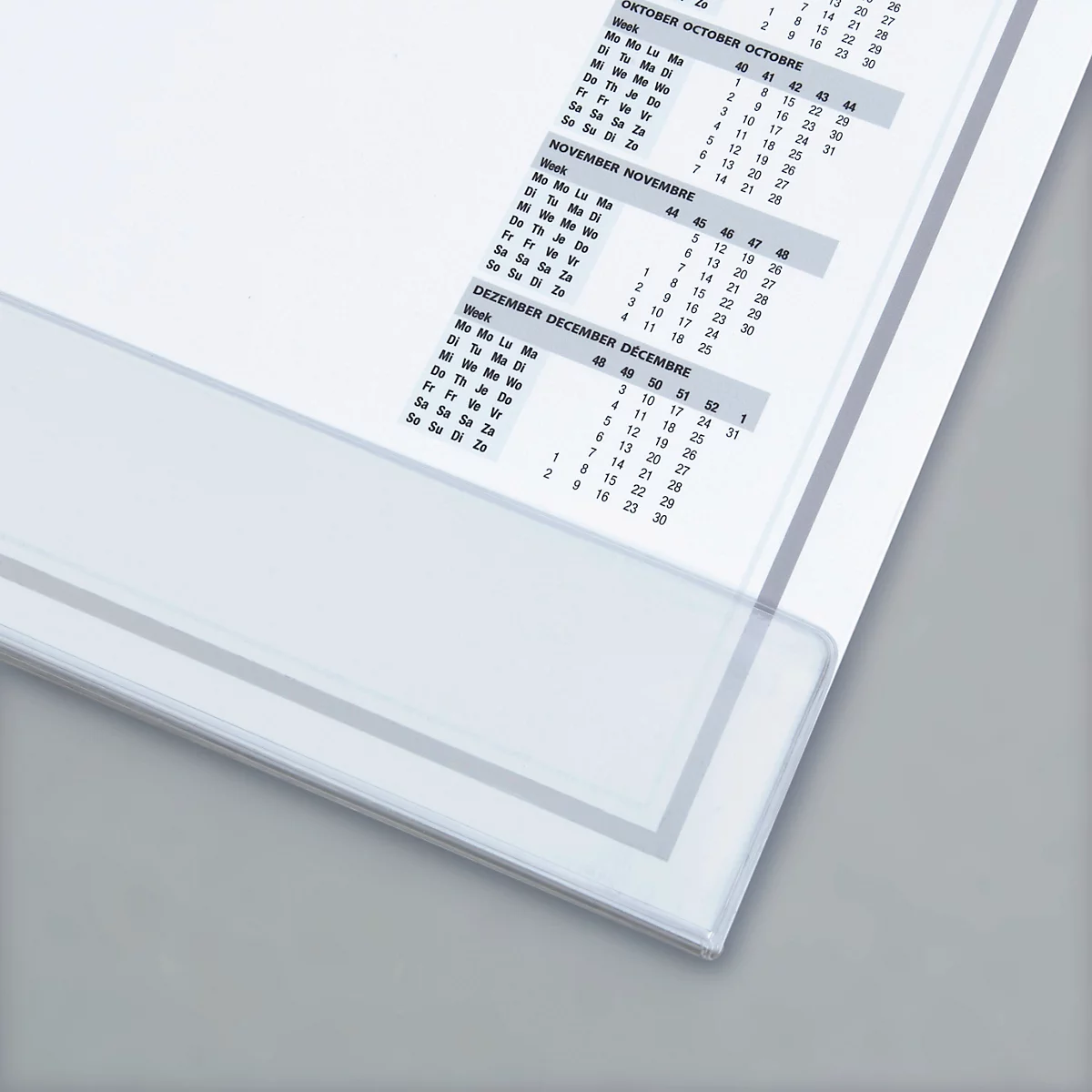 A semi-transparent, white calendar open. The months of October, November and December are visible. Below a gray background.