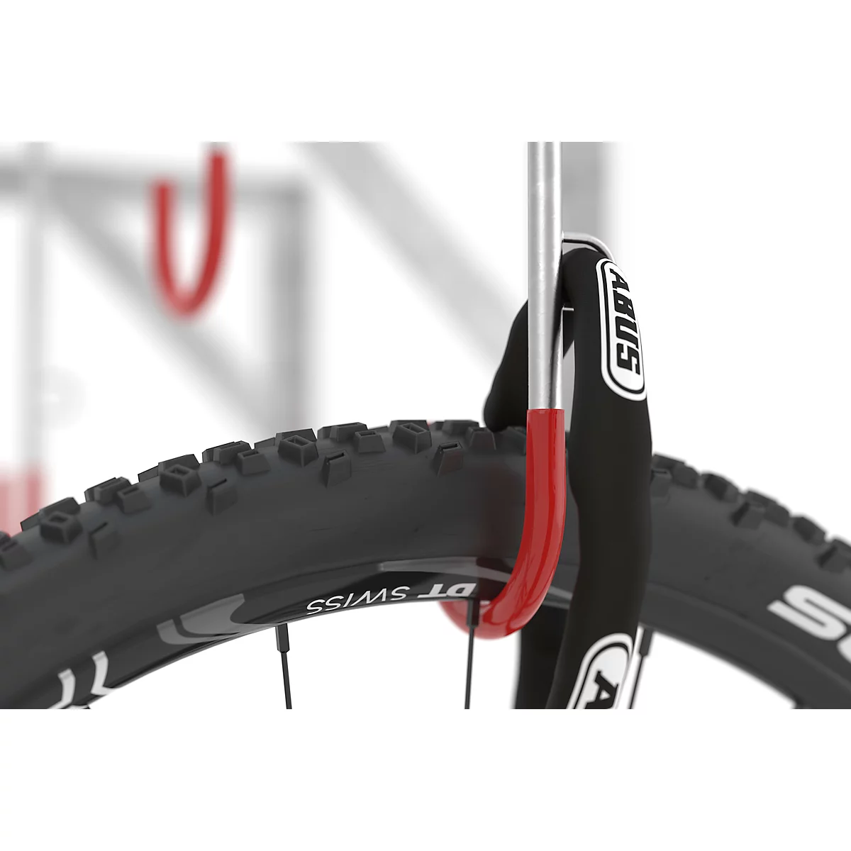 A bicycle tire with an ABUS lock secured to a red bracket.