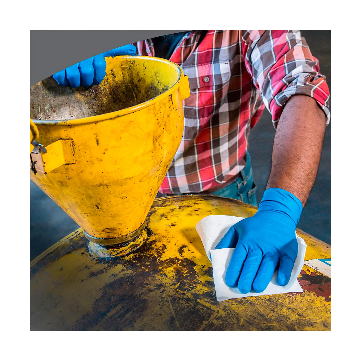 Persoon in rood geruit overhemd die gele apparatuur schoonmaakt met blauwe handschoenen en een doekje.