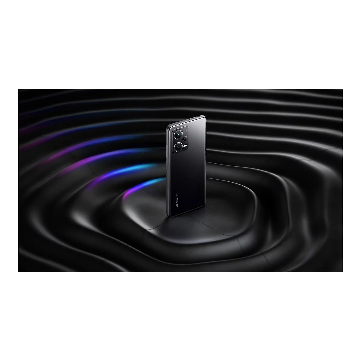 Schwarzes Smartphone auf wellenförmigen, glänzenden Untergrund. Lichtreflexe in Blau und Violett. Aufschrift "Redmi".