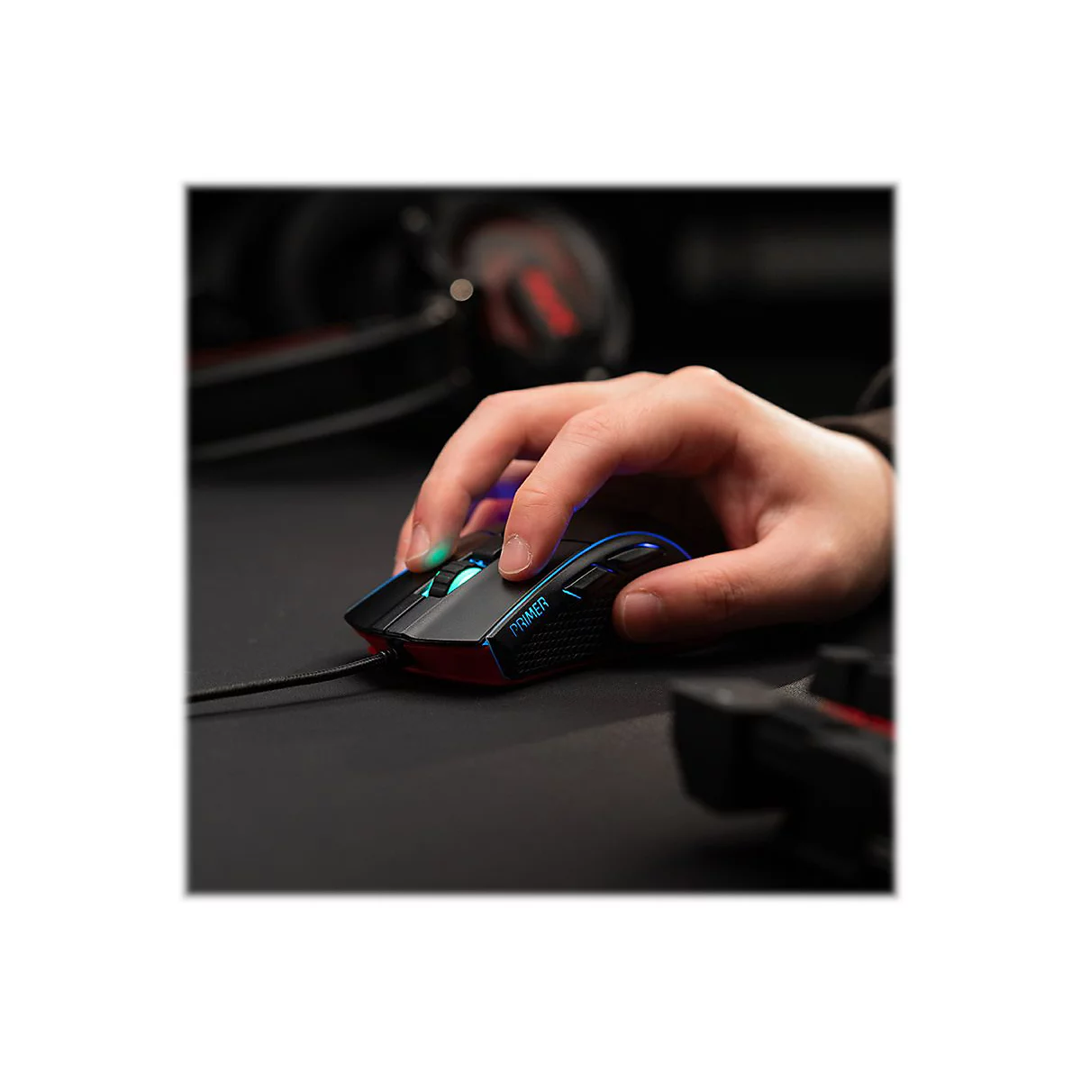 Hand auf einer schwarzen Gaming-Maus. Die Maus hat blaue und rote Akzente, das Kabel ist angeschlossen.