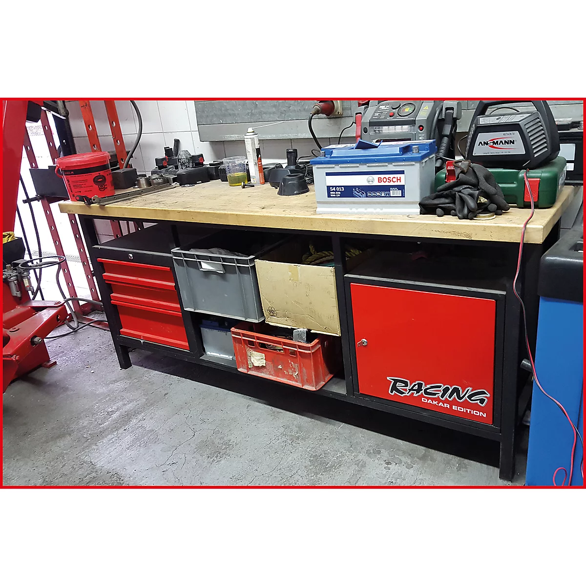 Werkbank in einer Werkstatt mit Batterieladegerät und einer Bosch-Batterie.