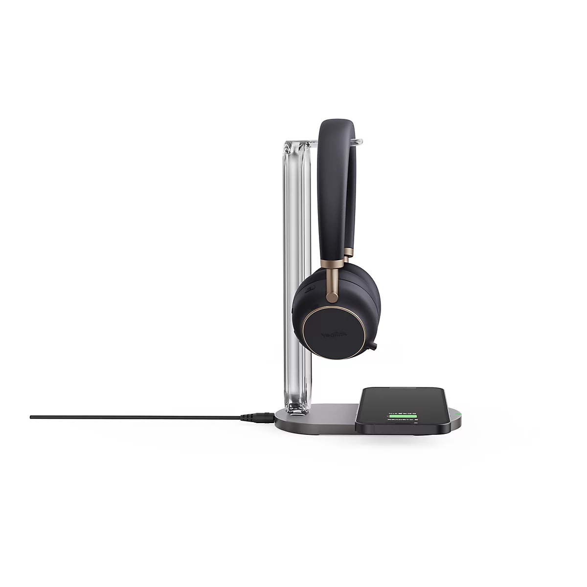 Casque sans fil noir et or sur un chargeur. Un smartphone avec un indicateur de charge est visible sur le chargeur.