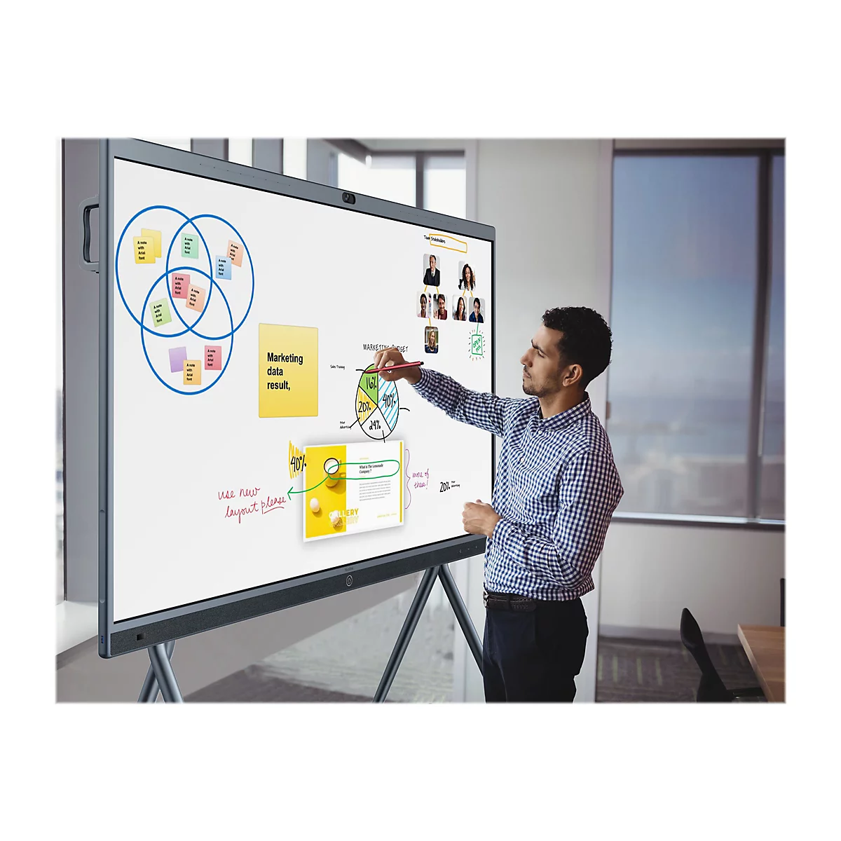 Ein Mann zeigt auf Diagramme und Notizen auf einer digitalen Tafel. Im Hintergrund ein Fenster.