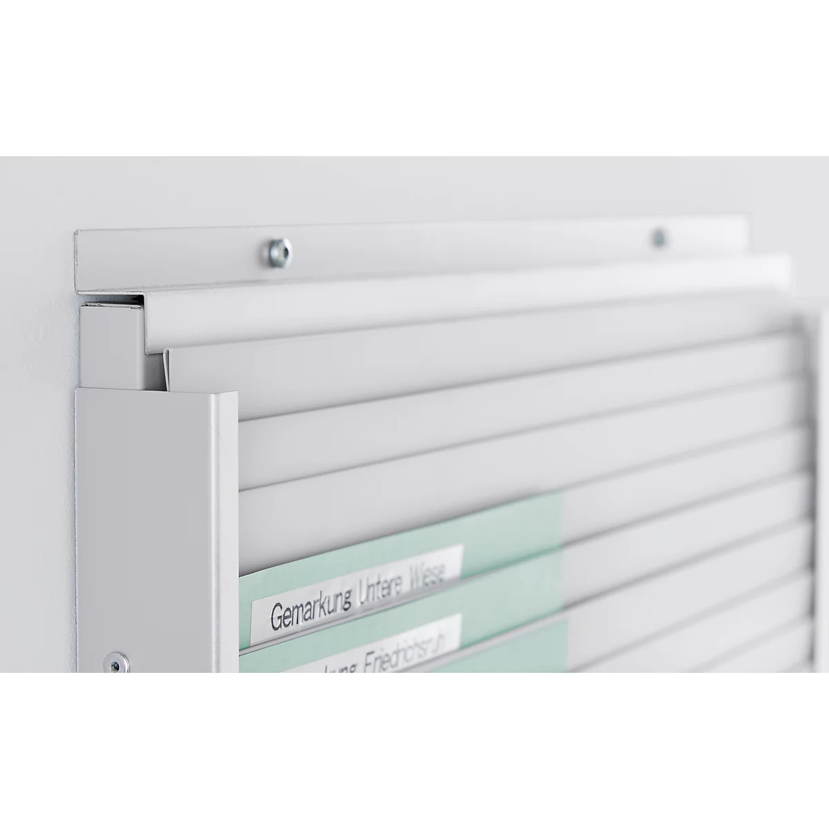 White wall shelf with labeled files. Light gray, clean lines, text: Gemarkung Untere Wiese.