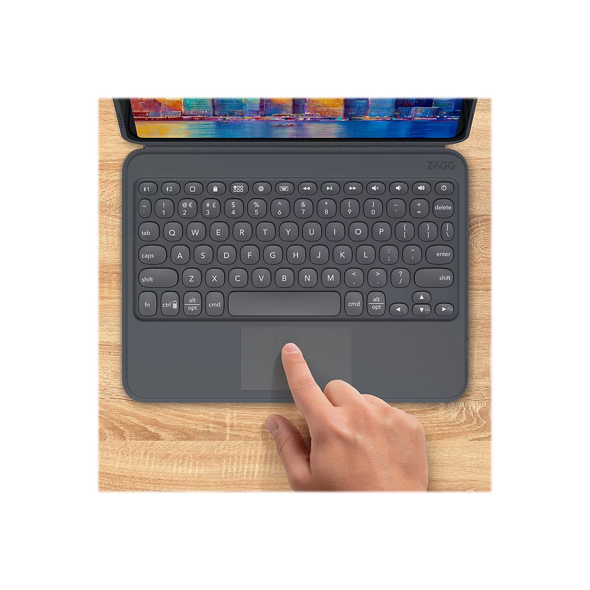 Clavier de tablette gris avec pavé tactile, sur une surface en bois. Un doigt touche le pavé tactile.
