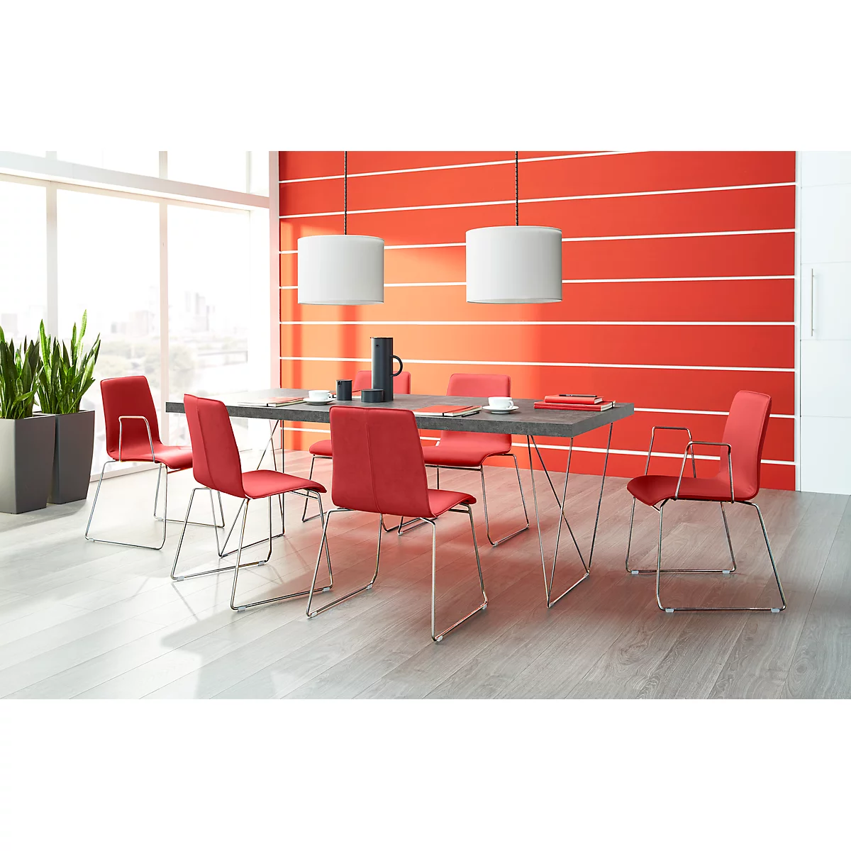 Dining room with table, chairs and lamps. Red wall, wooden floor.