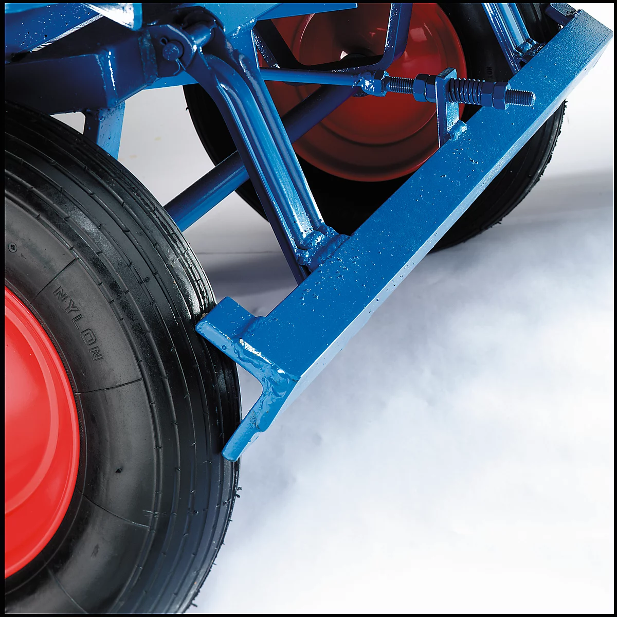 Close-up van blauw chassisframe met rode wielen en zwarte band. Een detail dat robuustheid en functionaliteit uitstraalt.